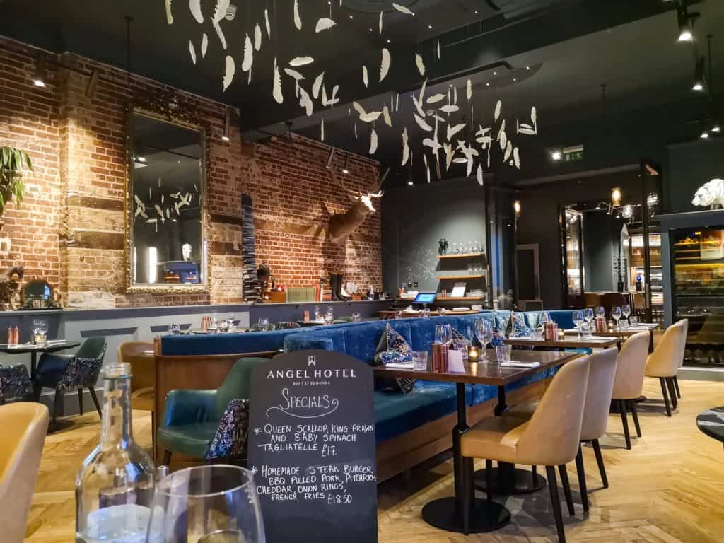 Inside of a Angel Hotel Bury St Edmunds pub with specials board and tables ready for a dinner.
