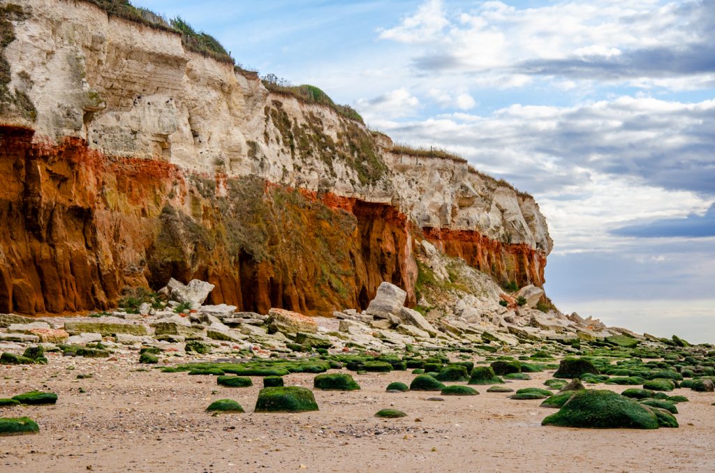 Old Hunstanton chalk red colour Cliffs and moss covered stones, one of the best beaches in Norfolk.