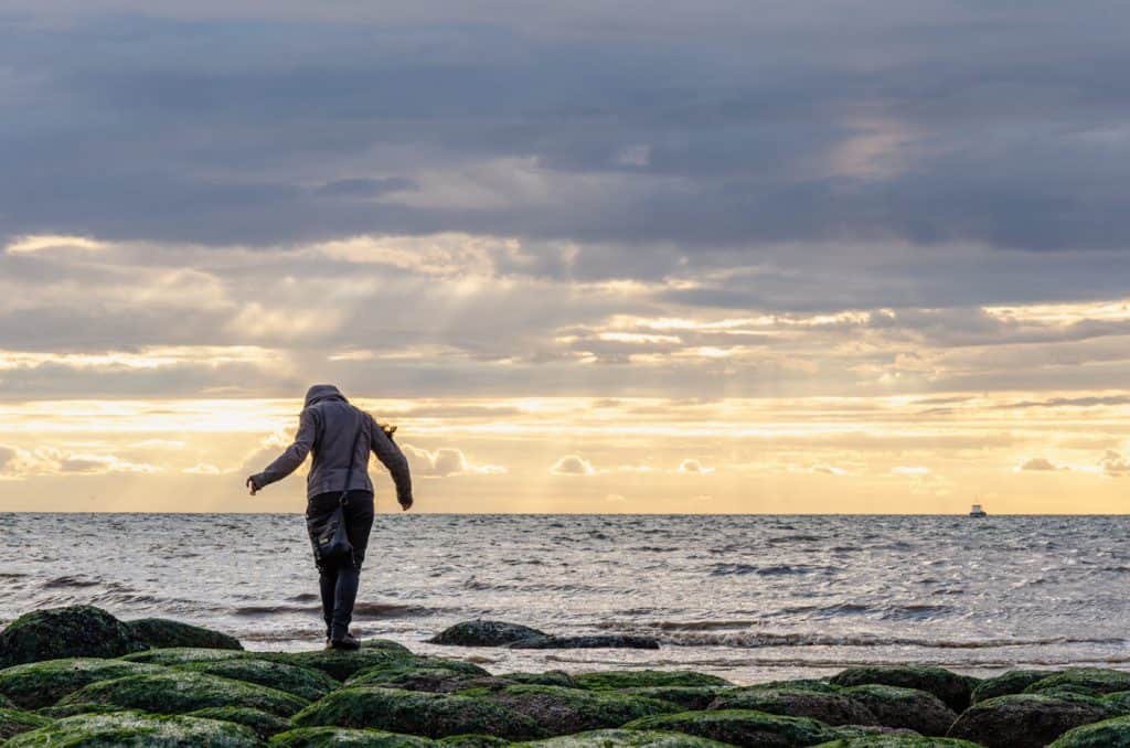 A women during sunset at Hunstanton Beach, one of the best beaches in Norfolk.