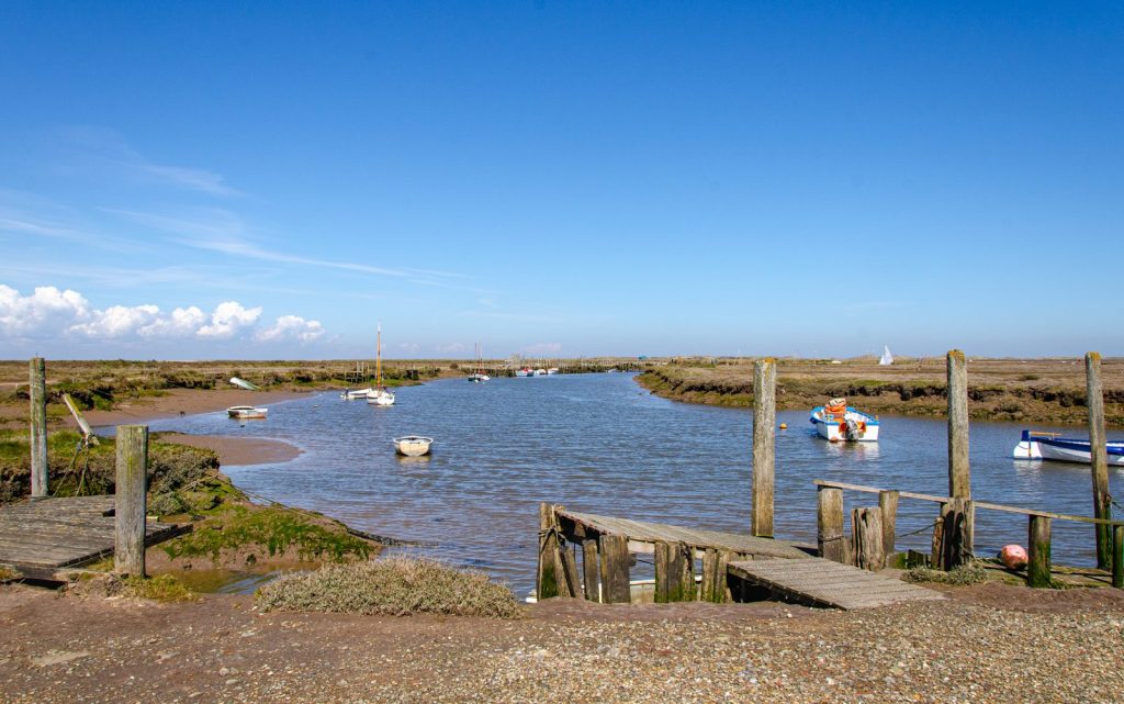 View at the creek with boats at Blakeney Point in East of England.