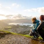 A couple looking at the town of Keswick from a viewpoint.