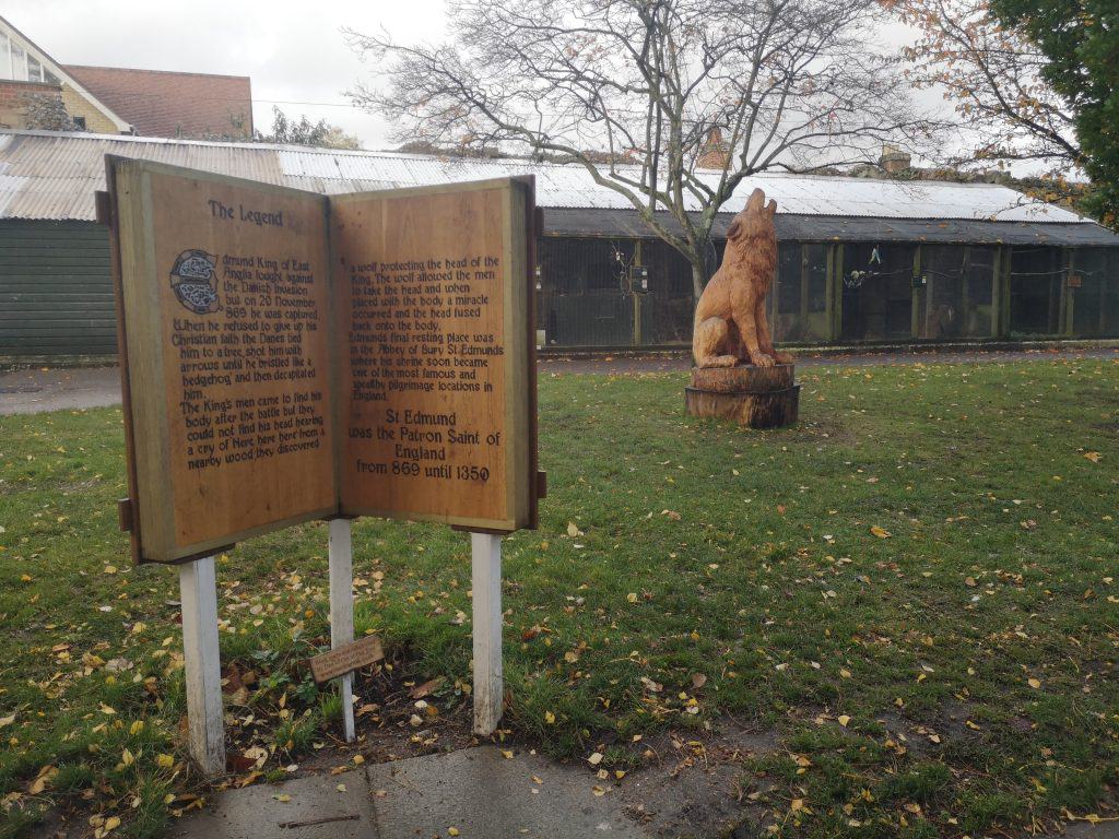 A statue of a wooden wolf and a book with a story of King Edmunds from Bury St Edmunds.