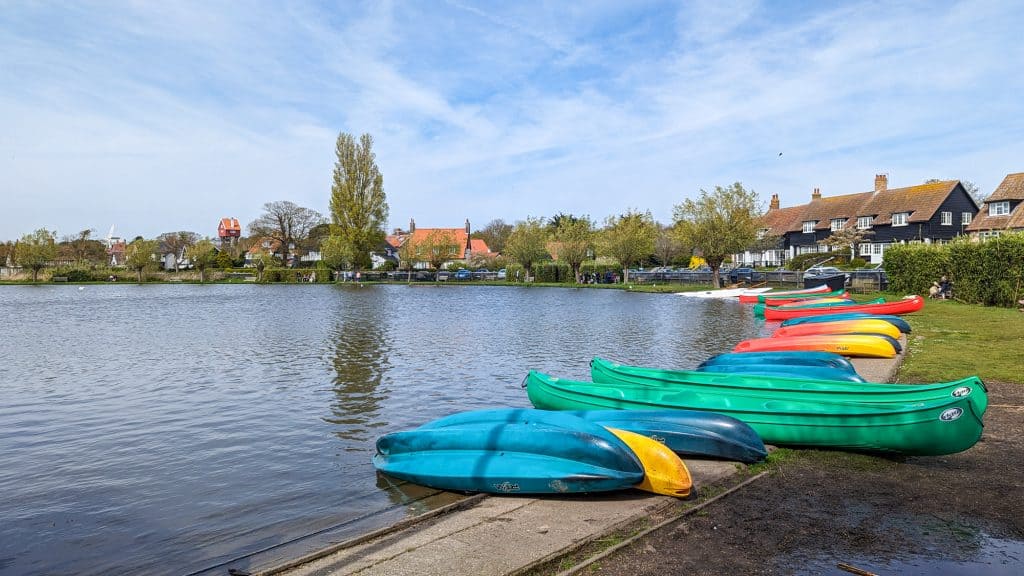 Kayaks and boats on the lake in Thorpeness in Suffolk Coast and Heaths AONB.