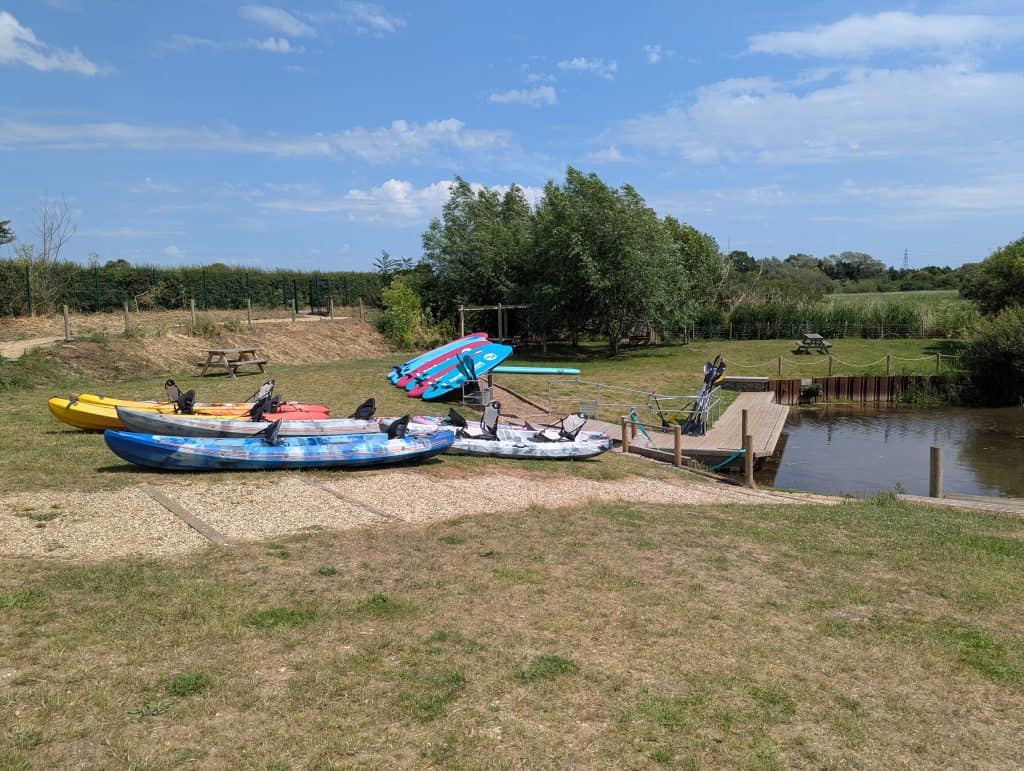 Kayaks on the shore of the river near Dedham Vale on a sunny summer day.