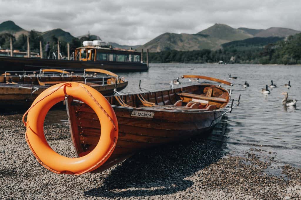 Boats with ducks at the shore of Derwentwater Lake.
