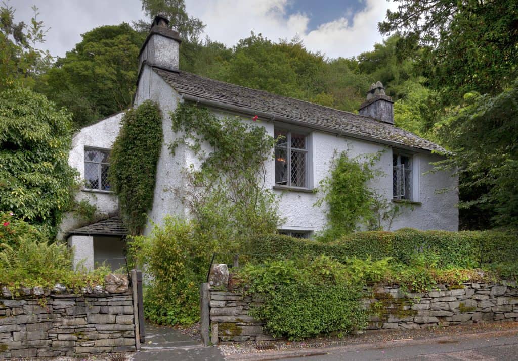 Dove Cottage with opened windows and trees.