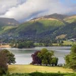 A lake with colourful trees and hills, one of the walks around Grasmere.