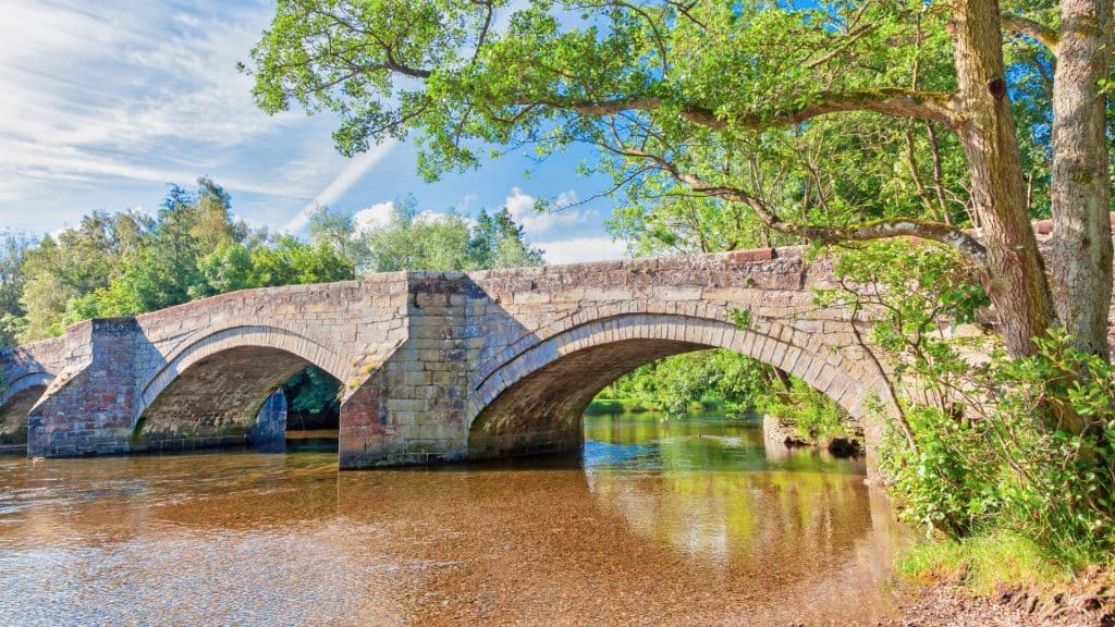 An old bridge with river on a sunny day near Ullswater.