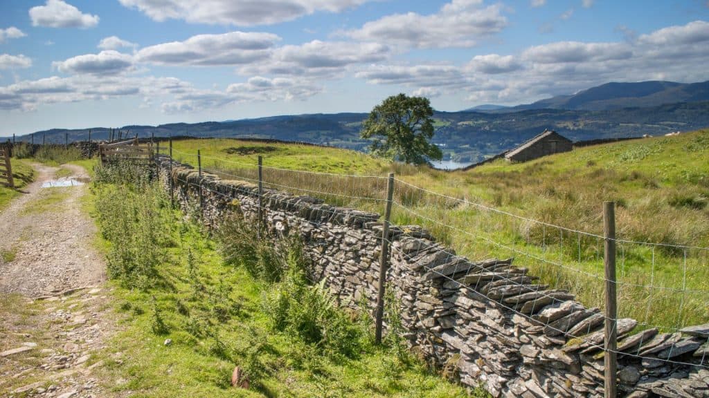 A footpath with hills and lake at back.