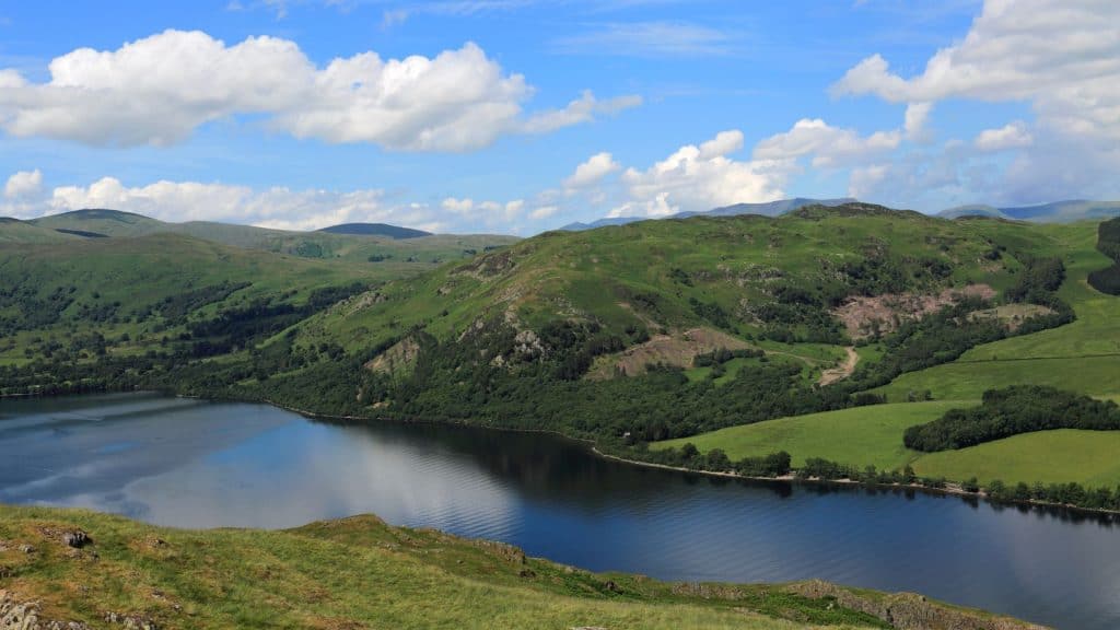 View at a lake and green hills on a sunny day.