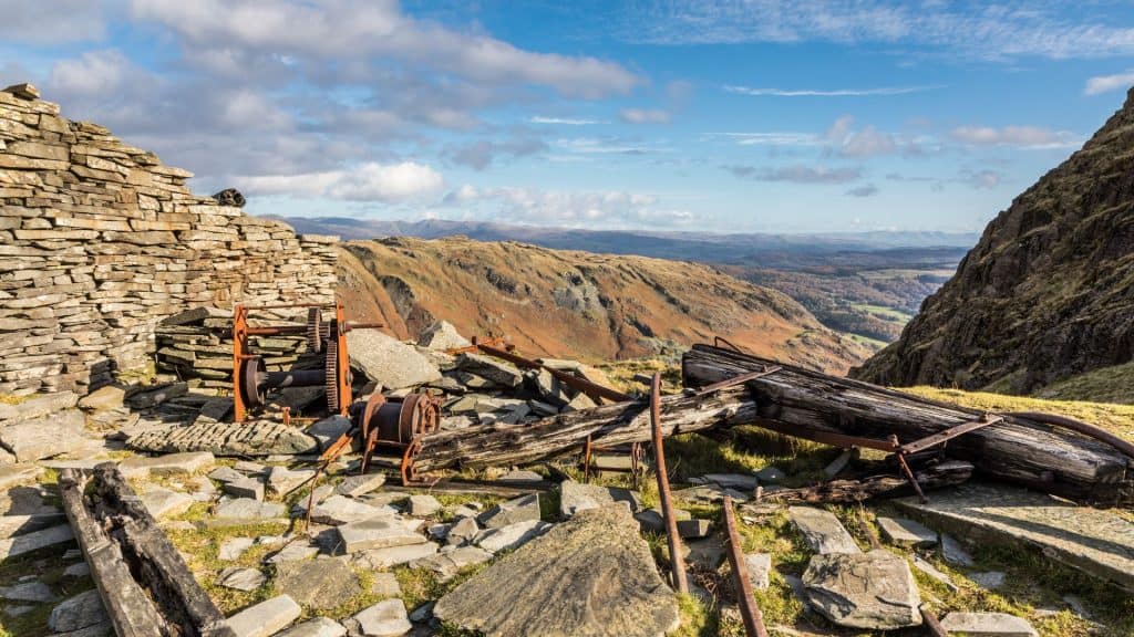 Steel and wooden remains of an old copper mine with hills at back.