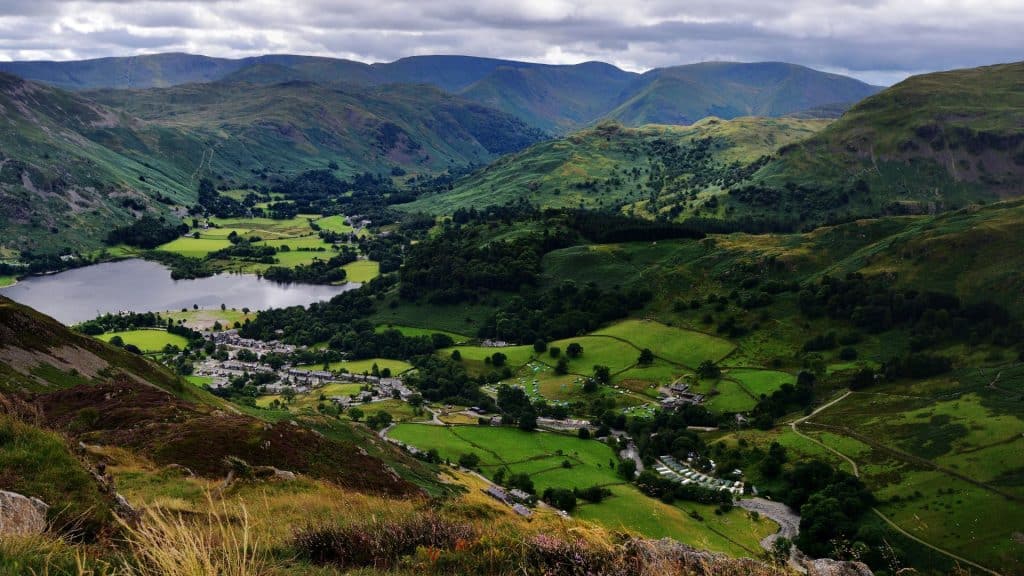 View at a valley with village, lake and green hills.