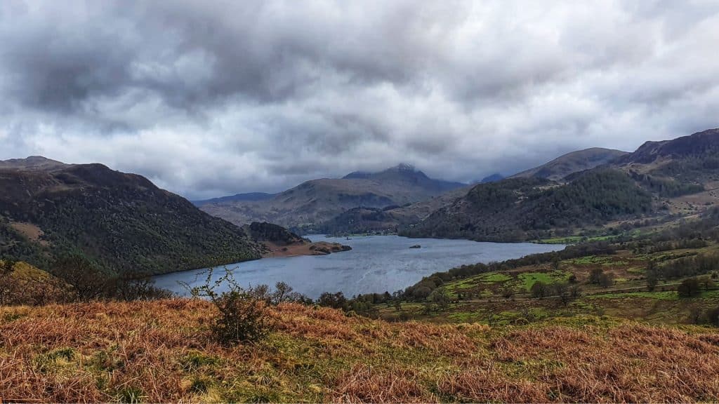 View at a lake with hills on a cloudy day.