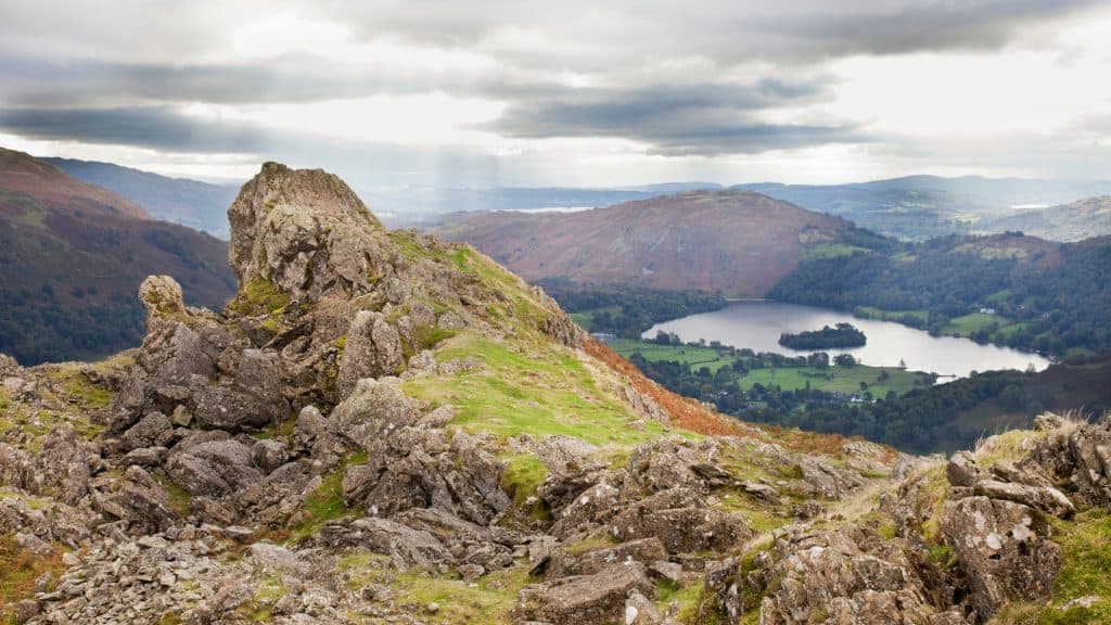 View at a rock formation with a lake at back in the Lake District.