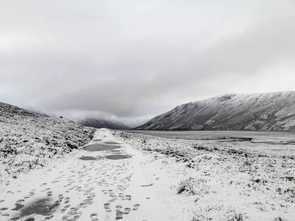View at a snow-covered landscape with a lake and mountains.