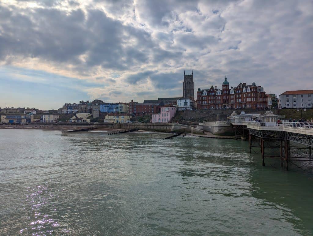 View at the beach, houses and a church in Cromer from the Pier, one of the best seaside towns in Norfolk and Suffolk.