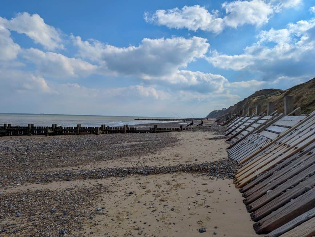 Trimingham Beach in Norfolk - view at the cliffs, people fishing and sea.