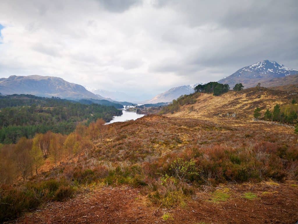 Views at a valley with a lake and mountains on a cloudy day in Glen Affric in Scotland, one of the hidden gems tips for a Scotland trip.