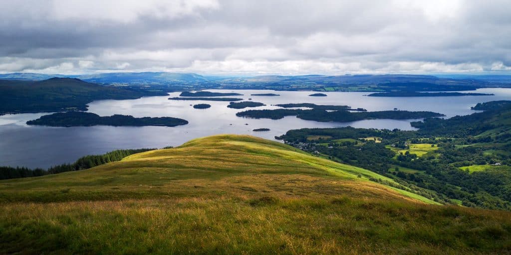 View at a lake and a valley in Loch Lomond national park, one of the must places to visit in Scotland.