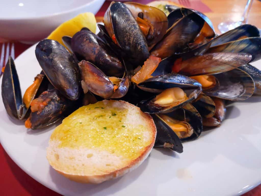 Food - a plate full of cooked mussels with bread.