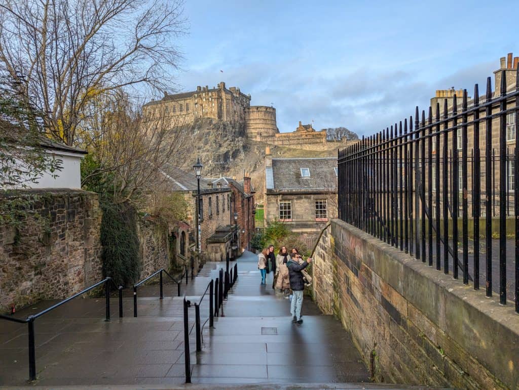 A view at the Edinburgh Castle with a group of people taking pictures.