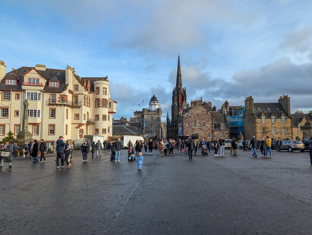 View from the entrance of the Edinburgh castle on people taking pictures and buildings at back.