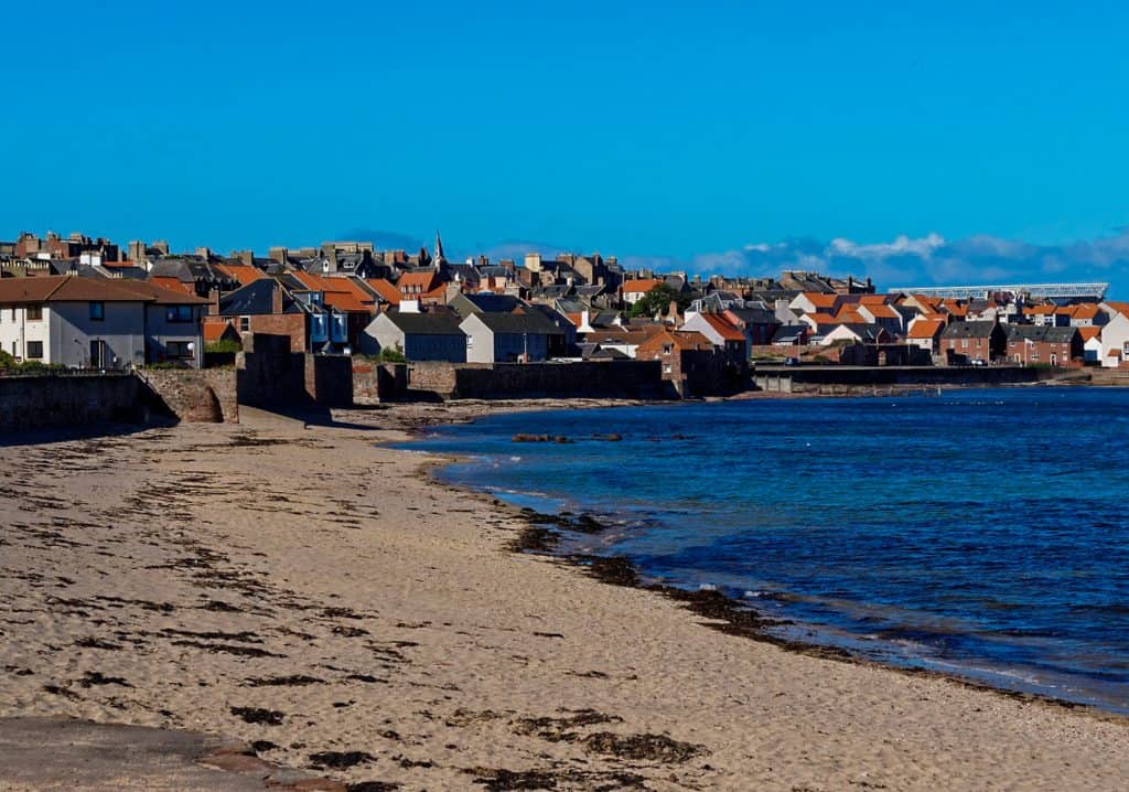 A view at the beach in Dunbar with houses at back.