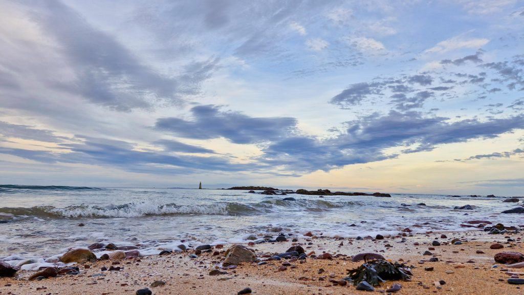Sunset at the Seacliff beach, one of the best beaches near Edinburgh, with a lighthouse at the distance, a perfect day trip from Edinburgh.