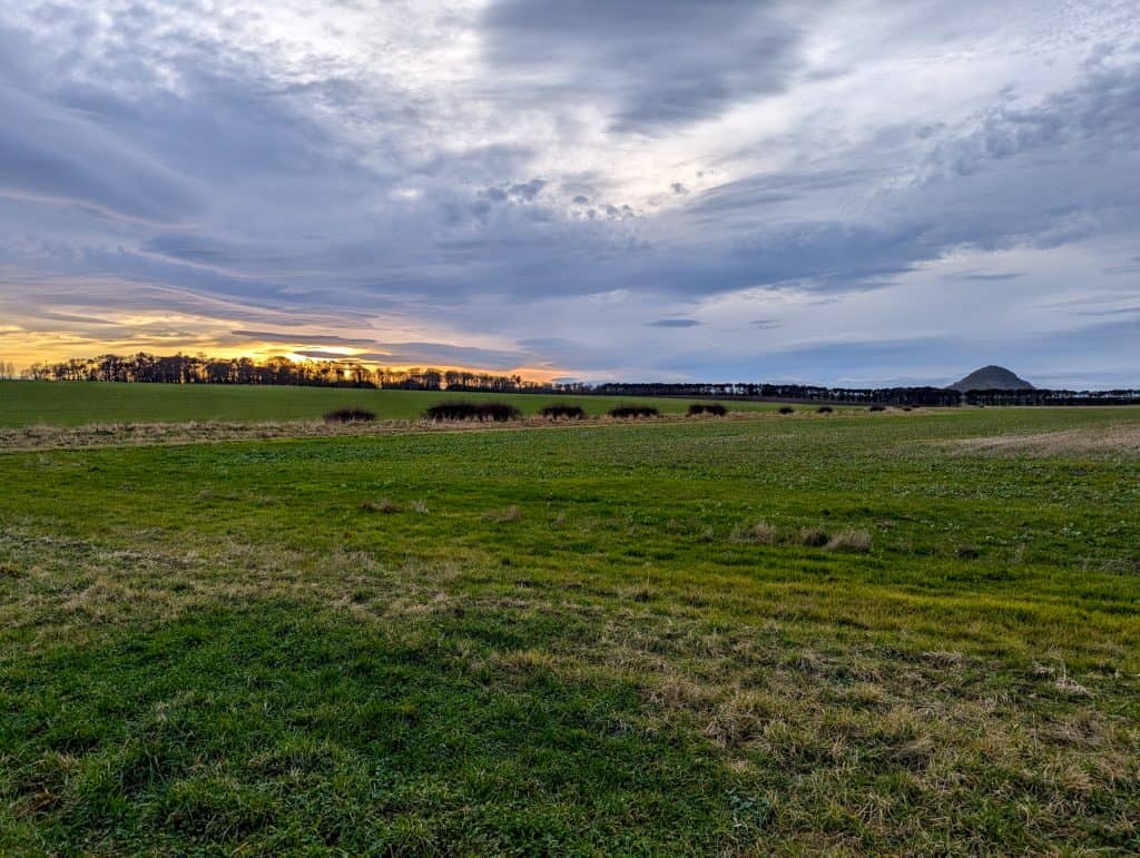 A landscape view with sunset near the Law in North Berwick Scotland. A trip to the Law is one of the best things to do in North Berwick.