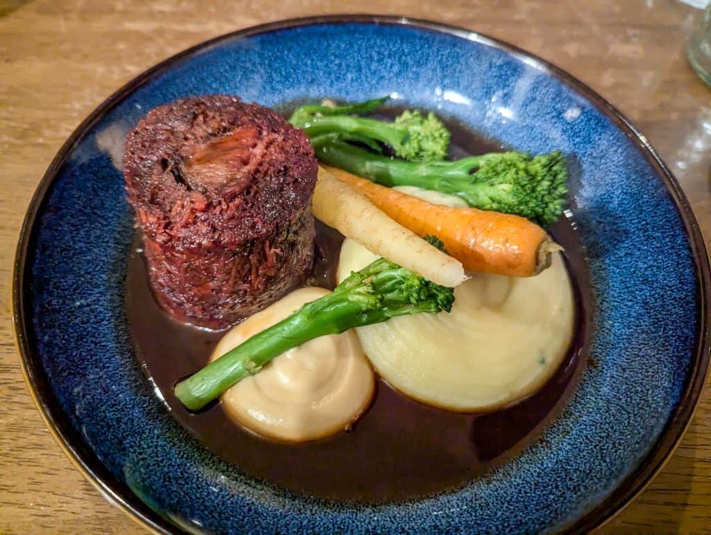 Beef Oxtail with vegetable mash and gravy on a plate.