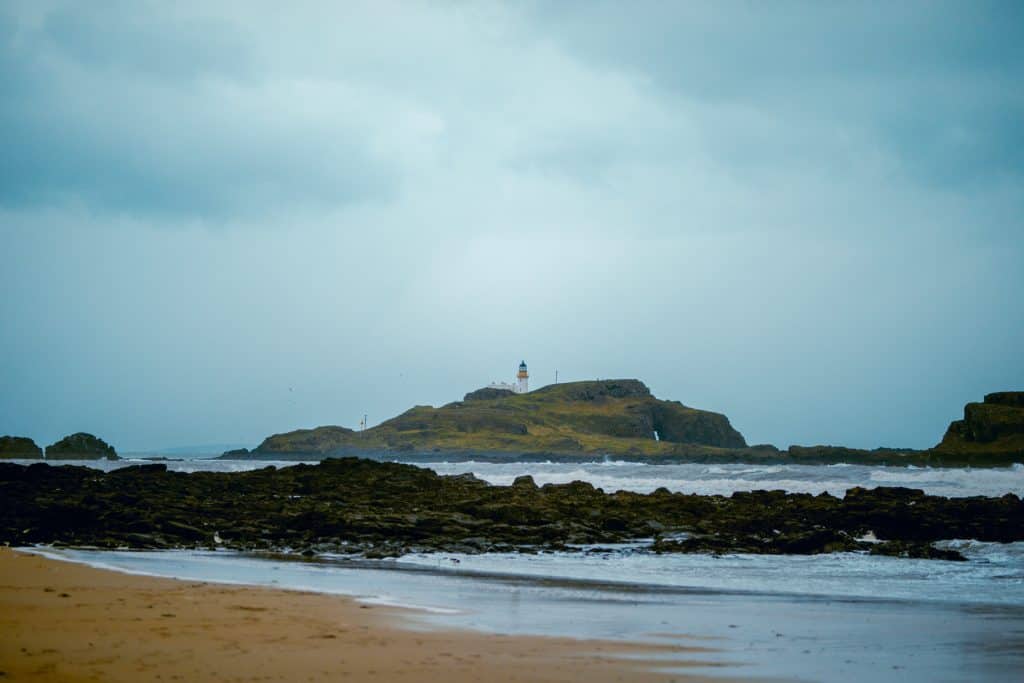 A view at the lighthouse with sea from the Yellowcraigh Beach in Scotland.