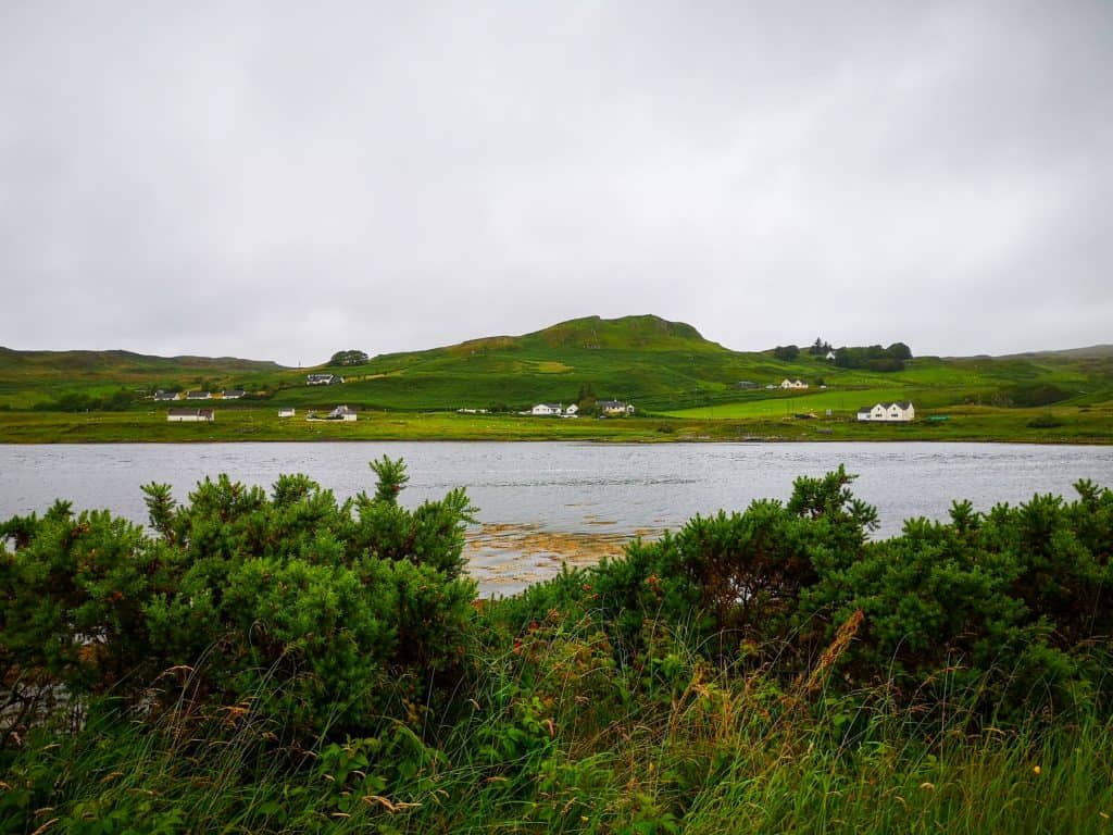 Viewpoint - Amar river with cottages and green hills at distance on a cloudy day.