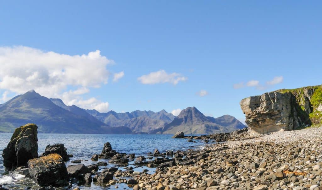 Rock formations and mountains at the Elgol beach on a sunny day.