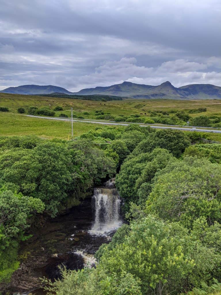 View at the Lealt Falls waterfall with mountains at back in summer.