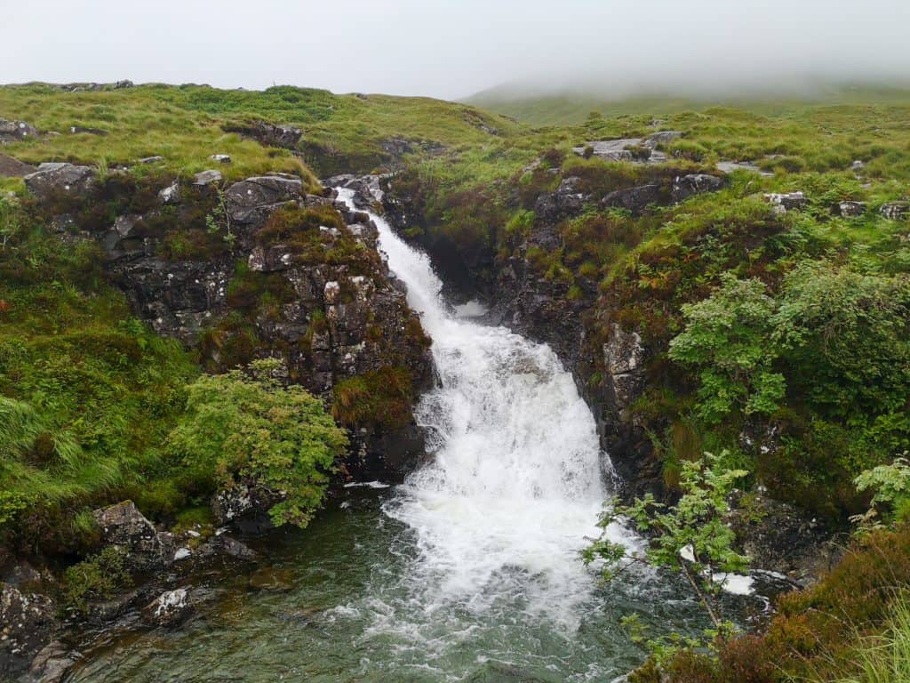 A detailed view on the Sligachan waterfall on a foggy day.