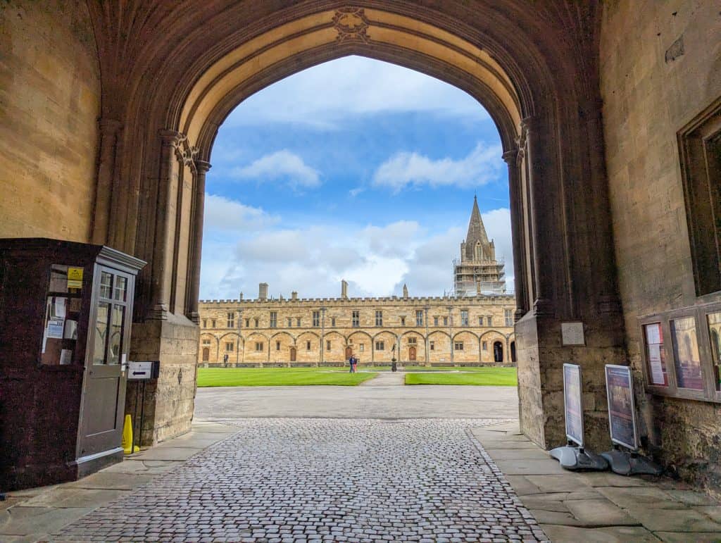 View at the first court with grass and building of the Christ Church College in Oxford from the entrance gate. Visiting colleges is a must during a perfect day trip to Oxford.