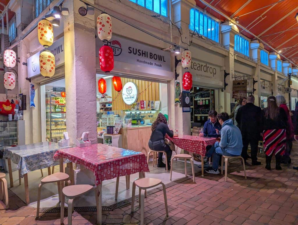 Oxford Covered Market - small stores with people eating and chatting.