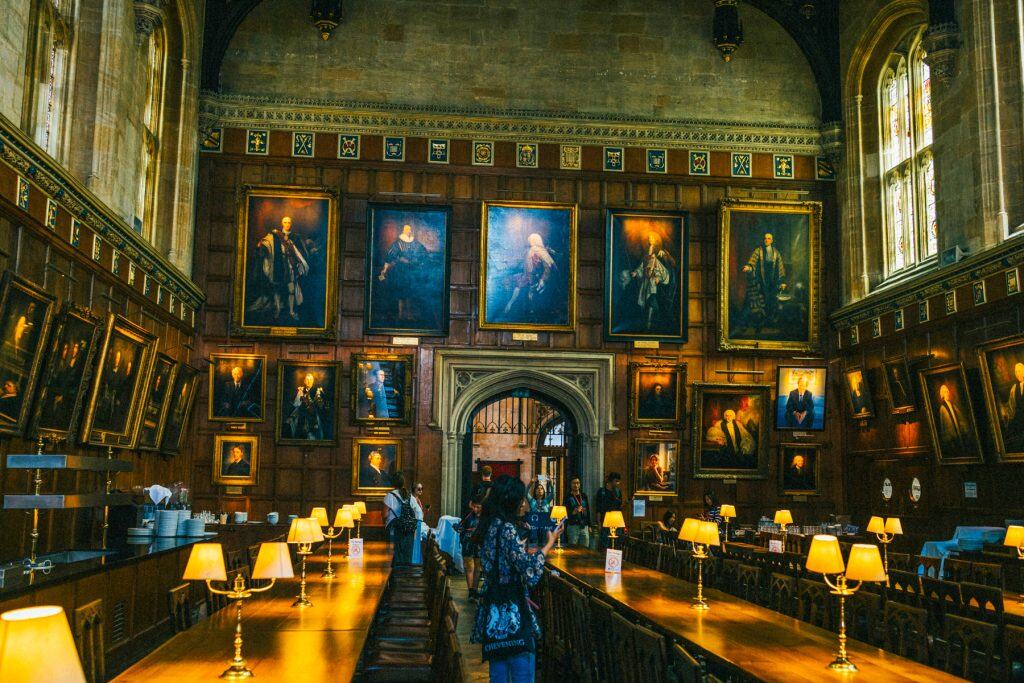 The Dining hall of the Christ Church college with portraits and tables.