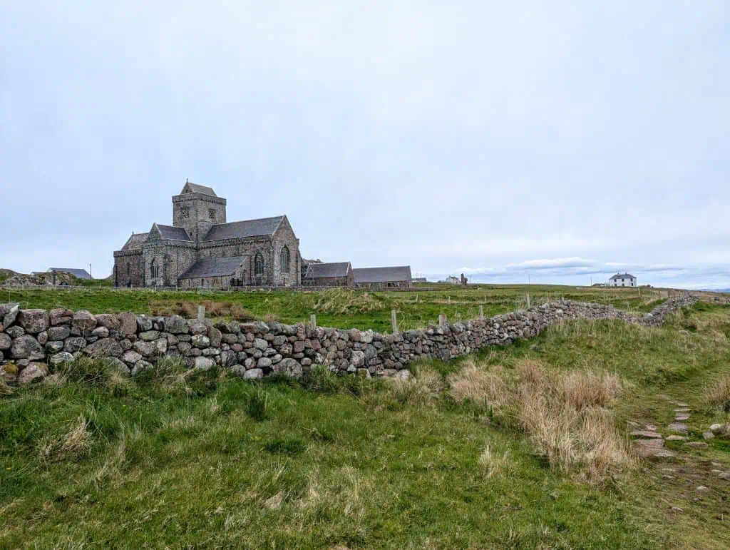 Iona Abby with meadows and a cottage at back.