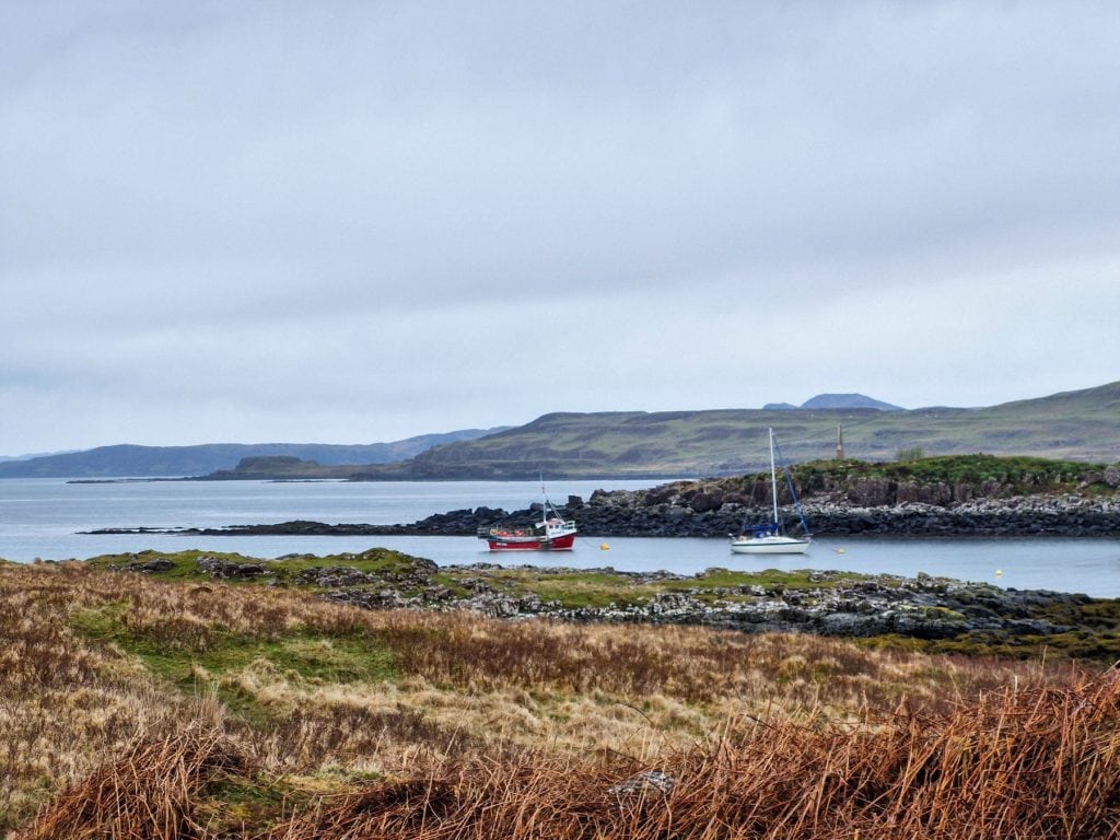Boats moored on a bay on Isle of Mull on a cloudy day.