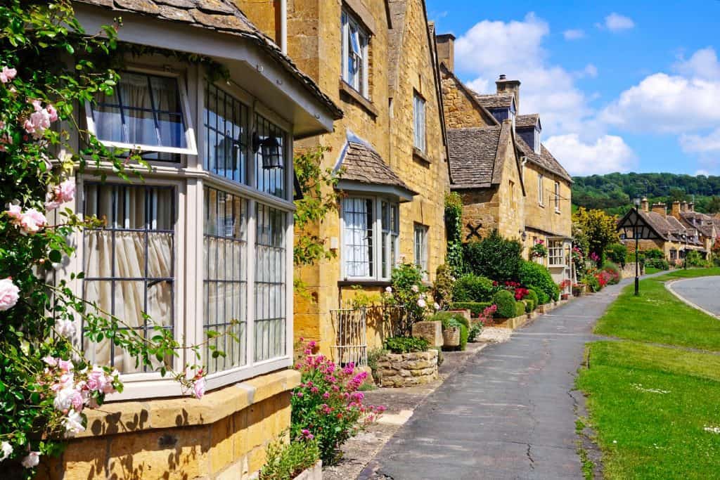 A street with historical mediaeval stone cottages on a sunny day.