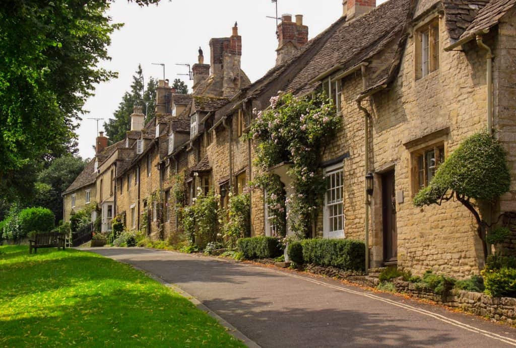 A street with historical mediaeval stone cottages on a sunny day.