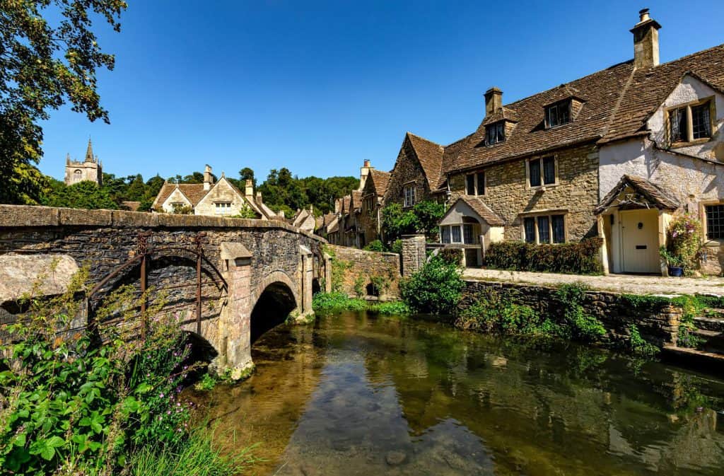 Old stone cottages with a mediaeval bridge and river.