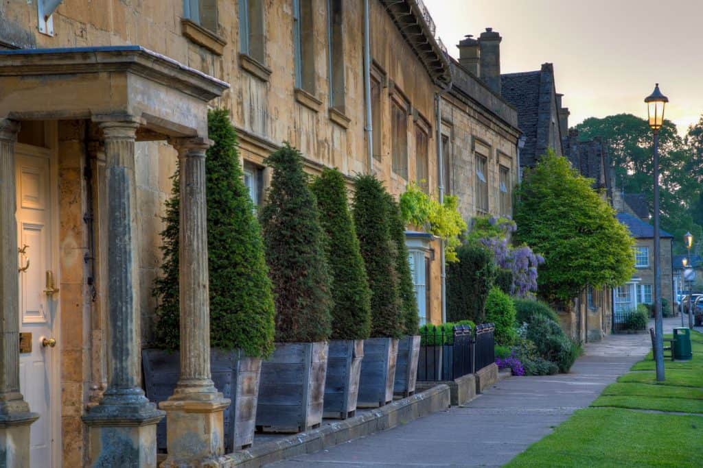 A street with historical mediaeval stone cottages at sunset.