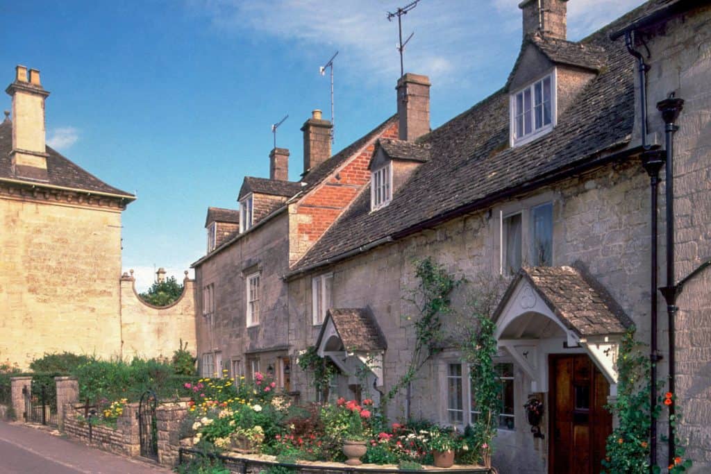 A street with historical mediaeval stone cottages on a sunny day.