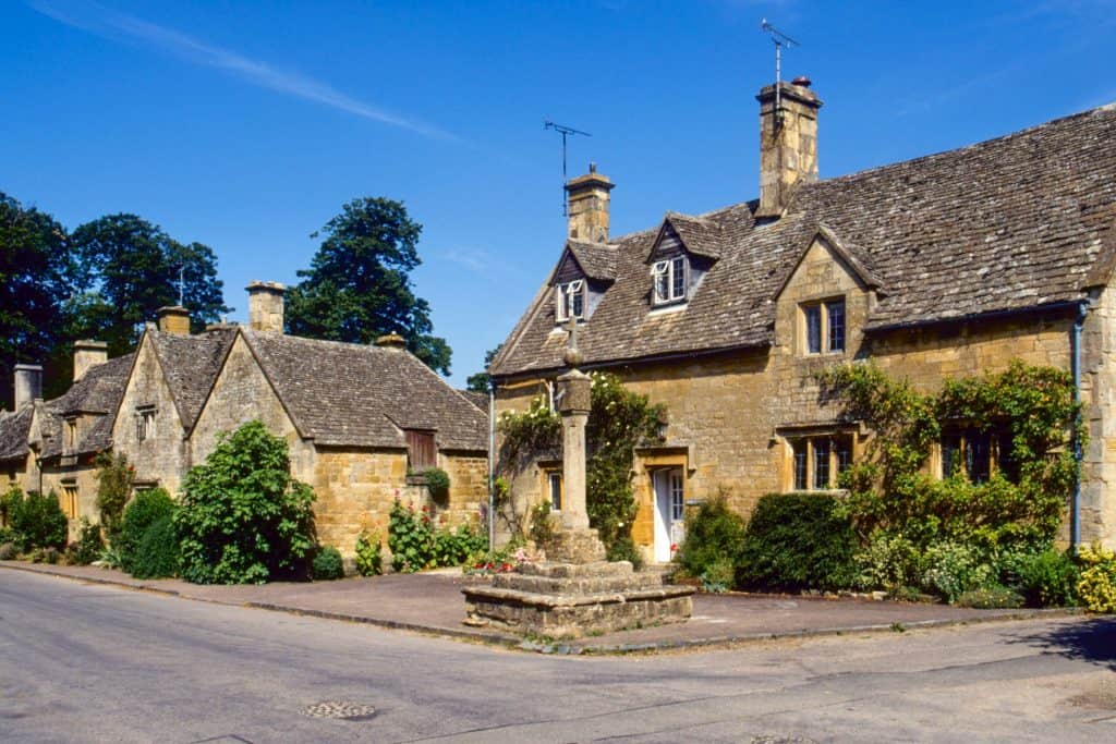 A street with historical mediaeval stone cottages on a sunny day.