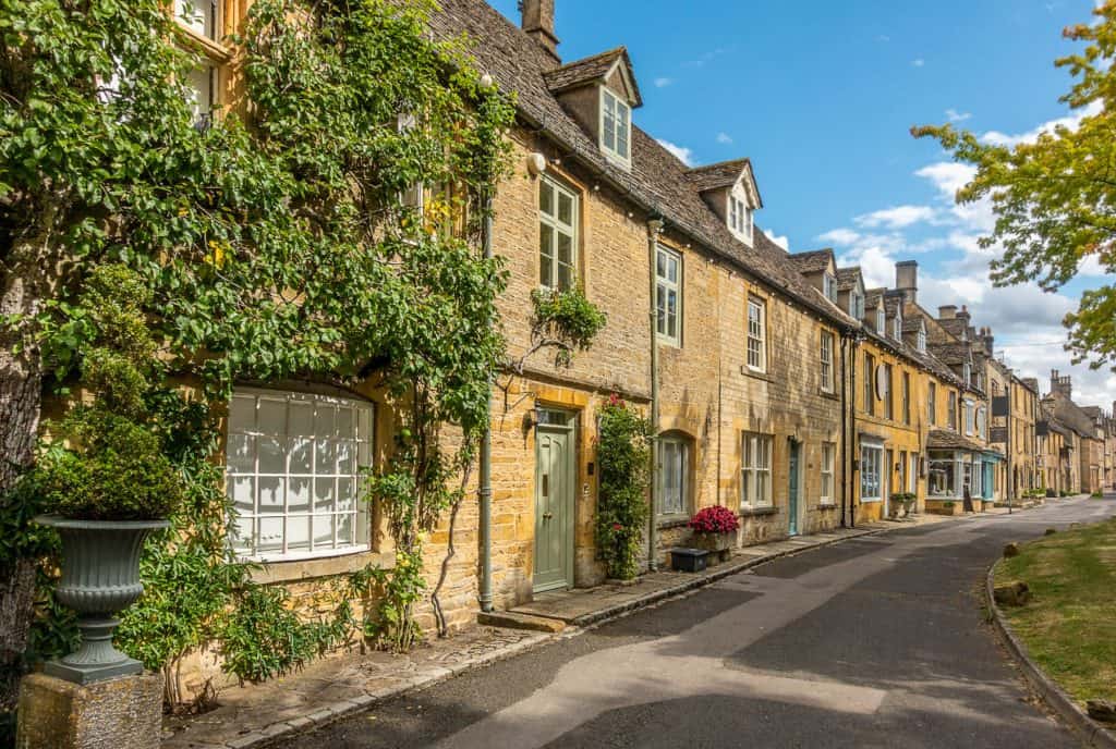 A street with historical mediaeval stone cottages on a sunny day.