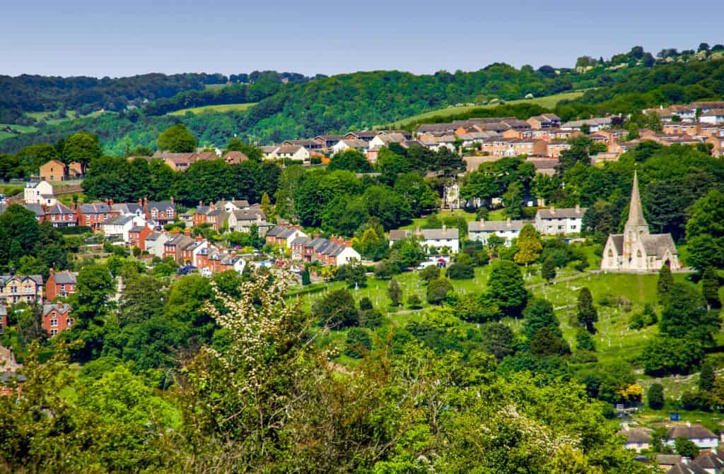 A historical town with cottages, church and trees.