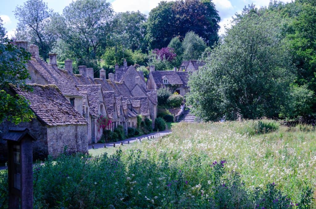 A view at a street with cottages in Bibury in spring, one of the best villages in the Cotswolds.