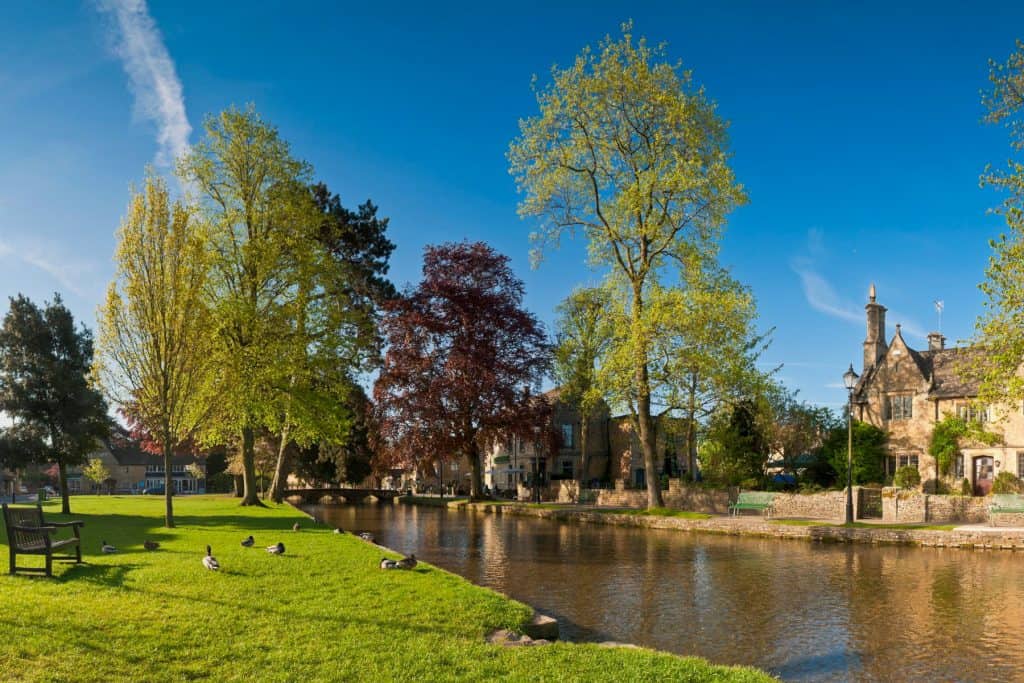 View at the river and house in a park in Bourton on Water in Cotswolds.